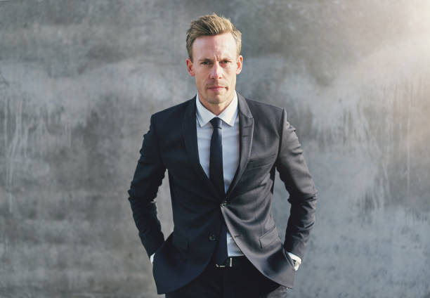 Businessman looks serious against the dark glass and steel of an office building