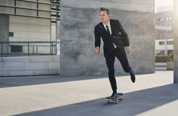 istock Confident successful man in suit riding skateboard 871805014