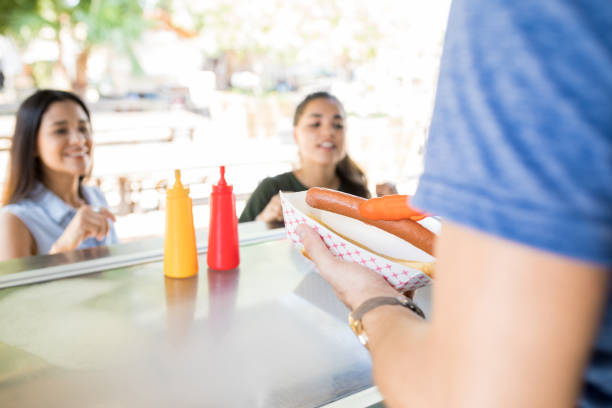 istock Serving hot dogs in a food stand 871819608
