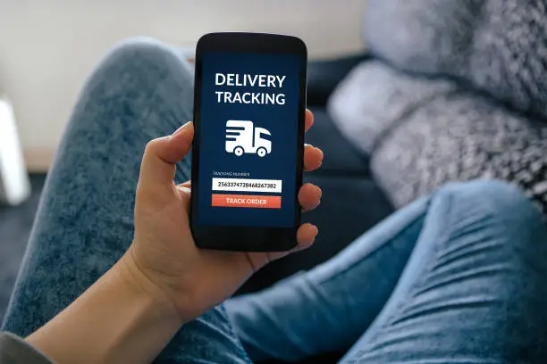 Photo of Girl holding smart phone with delivery tracking concept on screen