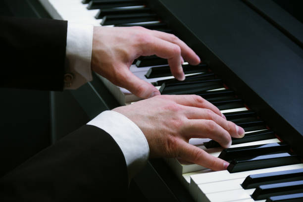 istock man's hands playing on a piano at the concert 871824352