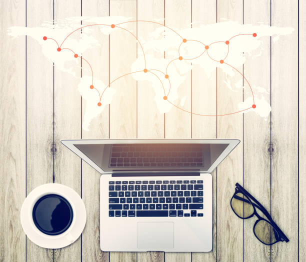 istock Top view of modern working  business office desk - notebook or laptop with connection worldmap network on wood table texture background, communication concept. 871824620