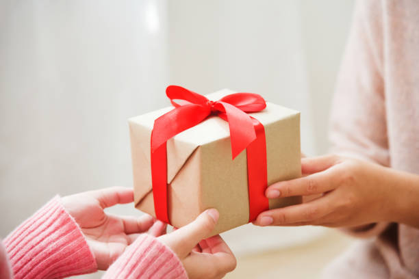 istock Asian woman hands giving a brown gift box. 871837504