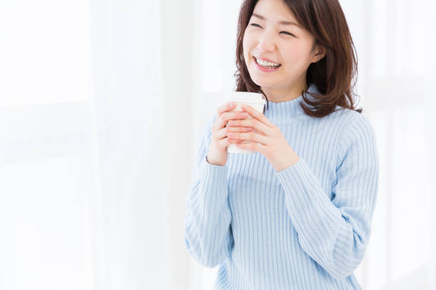 istock woman who takes a drink with a paper cup 871840876