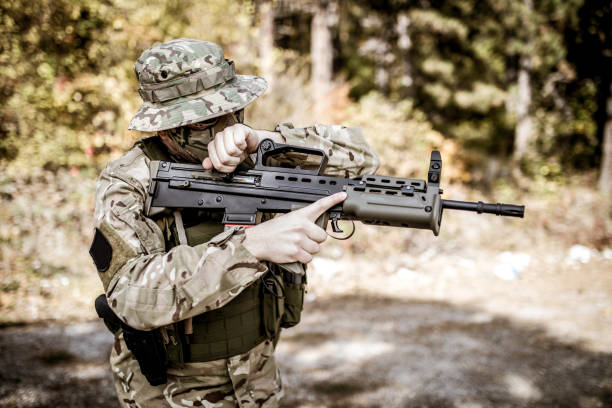 istock Soldier in camouflage holding a gun. 871847718