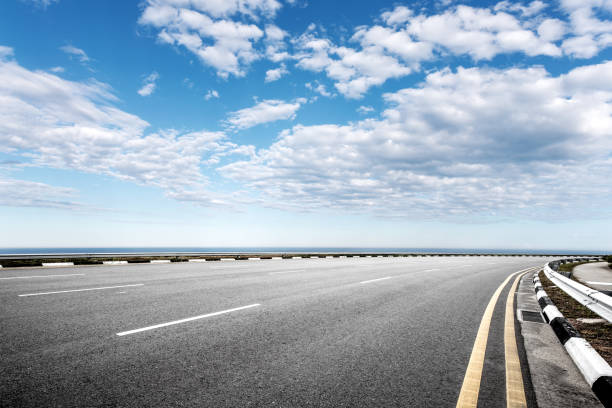 istock empty asphalt road with blue sea in blue sky 871853816