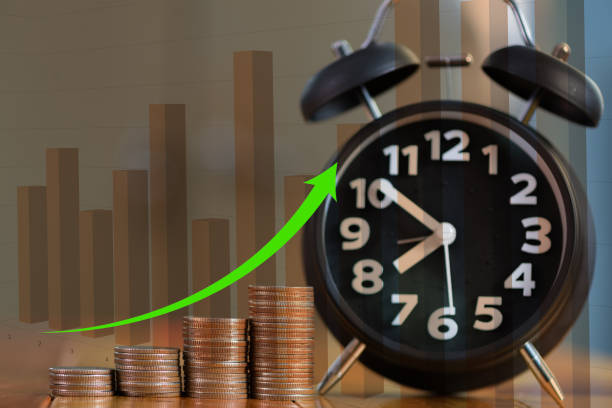 istock Double exposure of alarm clock and step of coins stacks on working table with financial graph, time for savings money concept. 871854348