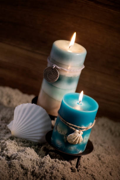 istock Blue candles with seashell on the beach 871856714