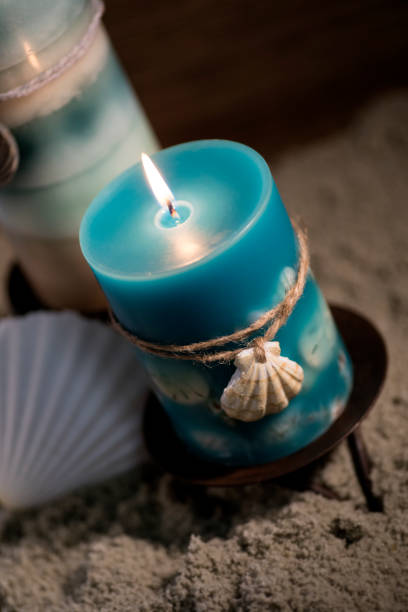 istock Blue candles with seashell on the beach 871856716