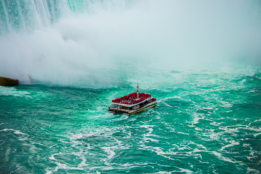 Niagara Falls, Canada - August 14, 2022: People having fun on a tourboat at the Niagara Falls in Canada