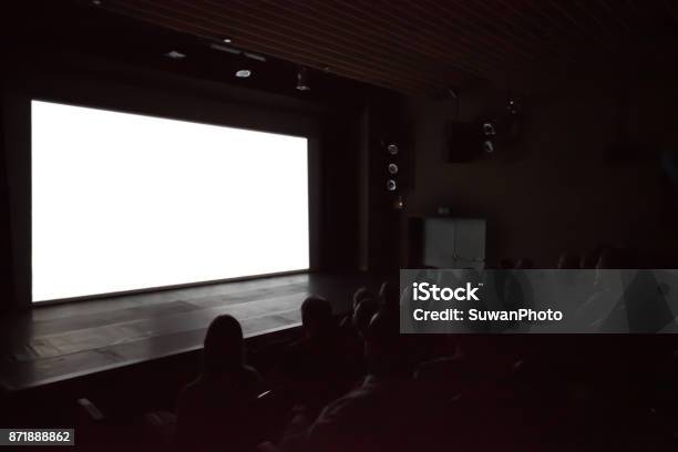 Blurry Background Of People Watching Movie In The Movie Theater With White Screen Stock Photo - Download Image Now