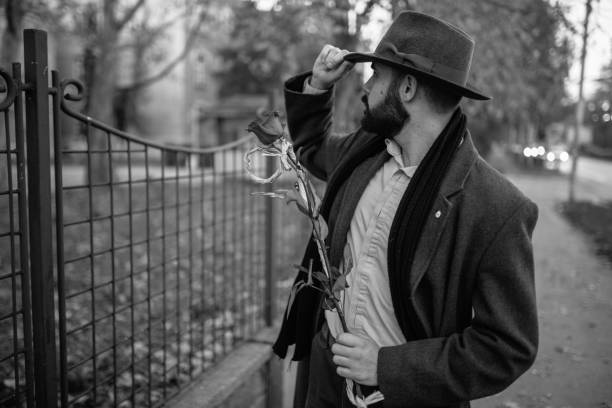 istock Handsome old-fashioned man carrying a rose 871889326