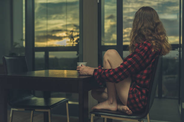 istock Woman drinking coffee in the morning by window 871893364