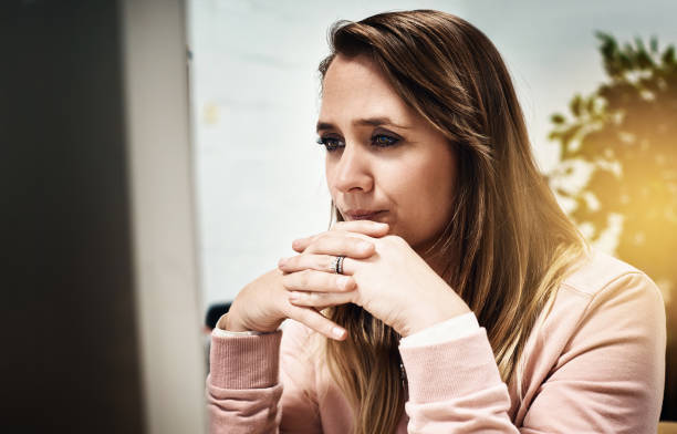 istock Beautiful blonde woman working on her computer concentrates hard 871896734