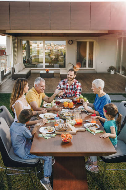 istock Happy multi-generation family communicating during lunch on a penthouse balcony. 871905632