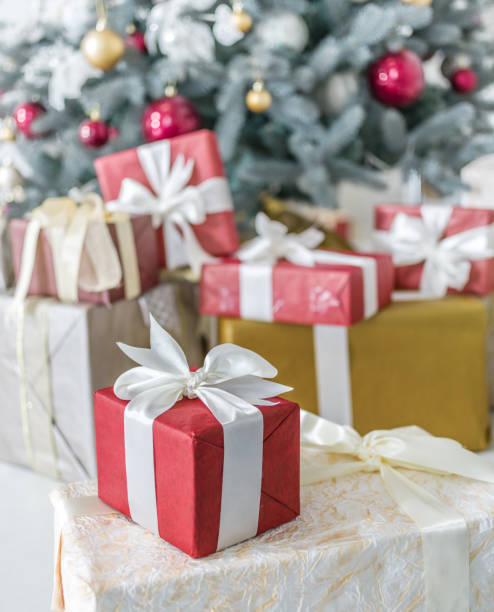 istock Red gift box and decorated New Year Tree on the background. 871908014