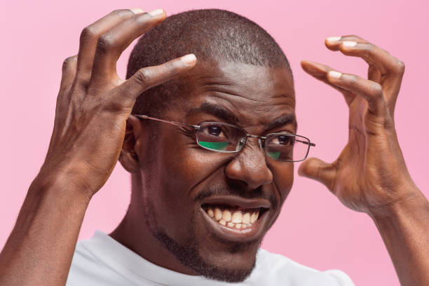 istock Black man holding his head in pain and depression 871908402