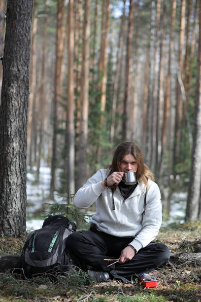 istock A man in a campaign drinks tea. A young traveler in the woods ca 871908438