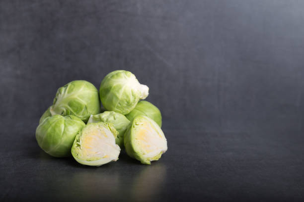 coles de bruselas en una mesa de piedra - brussels sprout raw brown close up fotografías e imágenes de stock