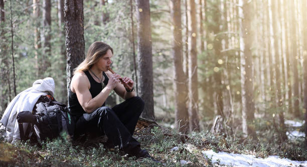 istock A musician with a tool in nature. A man is playing a flute in a 871908878