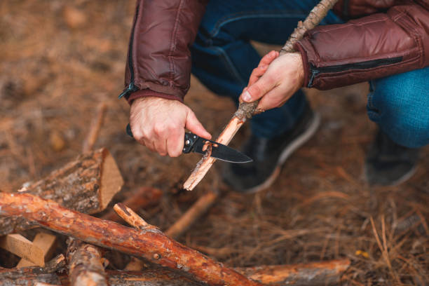 istock The hands of a guy with a knife grind a branch 871919812