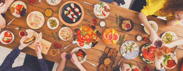 istock People clink glasses at festive table dinner party 871923590