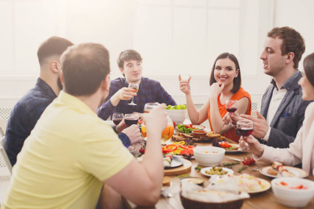 istock Group of happy people at festive table dinner party 871923736