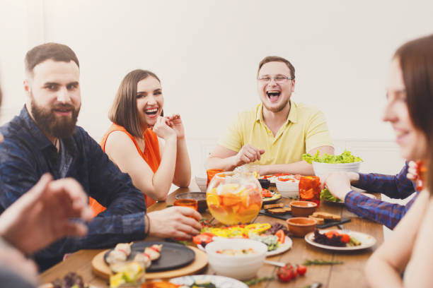istock Group of happy people at festive table dinner party 871924446