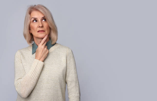 istock thoughtful old woman looking up. Isolated 871924676