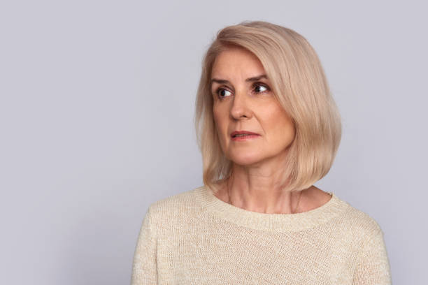 istock sad old woman looking away. Isolated 871927526