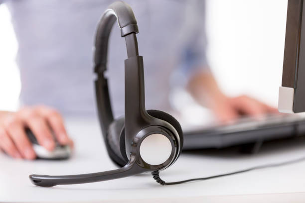 istock Office desk with headset, female agent and pc on background. Call center support concept 871927724