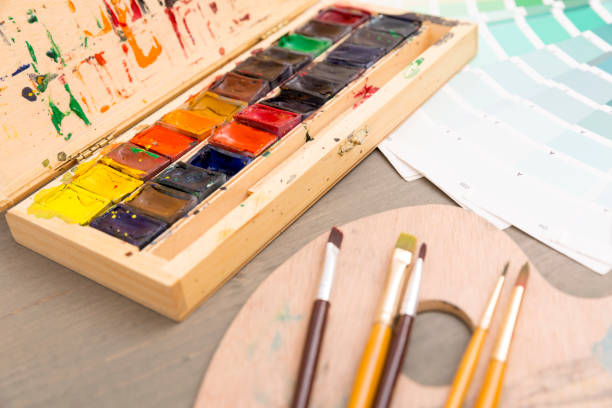 istock Paints for drawing, palette and brush on a wooden background 871928192