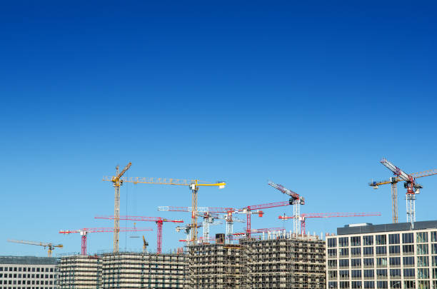 baustelle mit kran und blauer himmel - construction equipment large construction crane stock-fotos und bilder