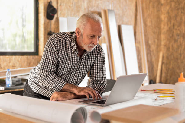 istock Mature designer in his workshop on laptop 871931258