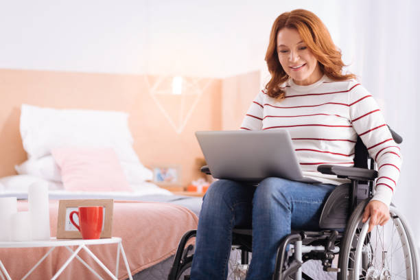 istock Smiling incapacitated woman working on her laptop 871935844