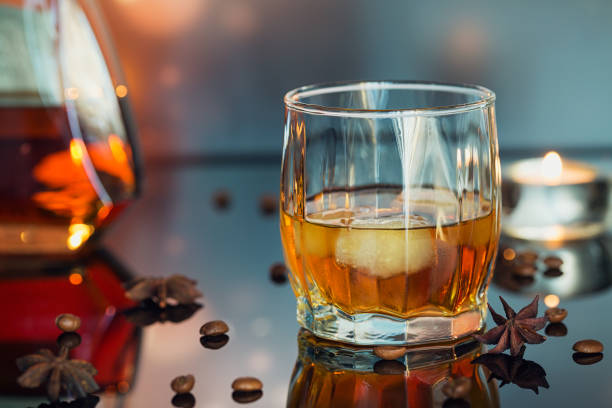istock Cognac or liqueur, coffee beans and spices on a glass table. 871936064