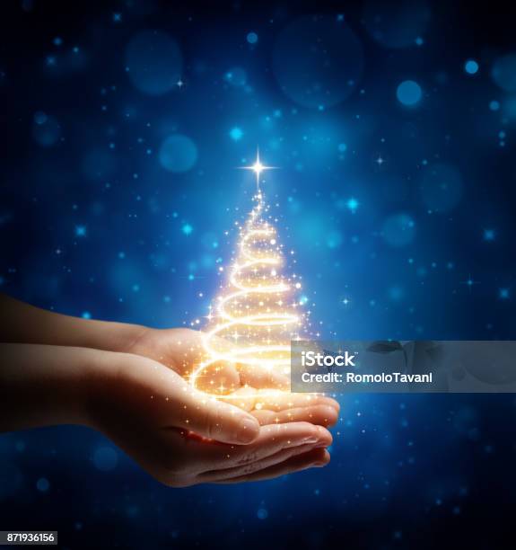 The Magic Of Christmas In Child Hands Stock Photo - Download Image Now - Christmas, Blue, Christmas Tree
