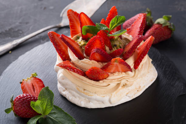 istock Anna Pavlova cake with strawberry on black background 871938618