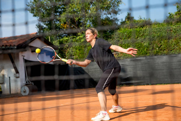 istock Active Woman Practicing Tennis Outdoors 871943424