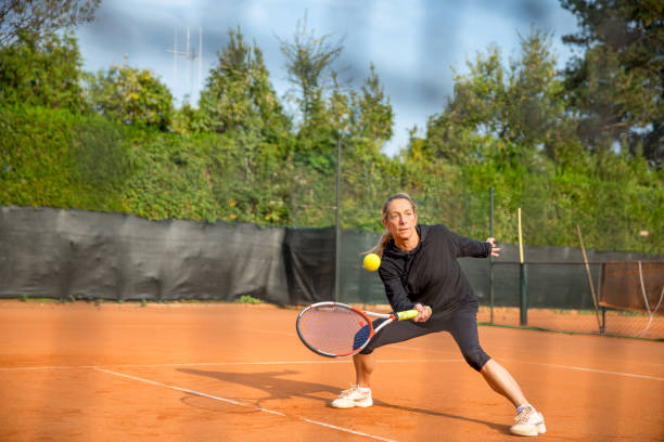 mujer adulta jugando tenis - athlete flying tennis recreational pursuit fotografías e imágenes de stock