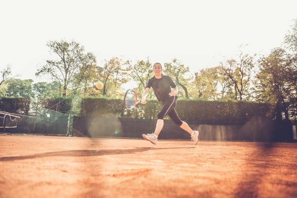 mujer persiguiendo la pelota - athlete flying tennis recreational pursuit fotografías e imágenes de stock