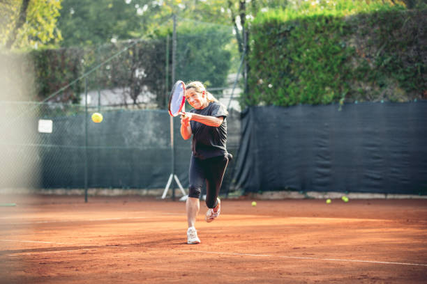 mujer jugador de tenis cercana a la pelota - athlete flying tennis recreational pursuit fotografías e imágenes de stock