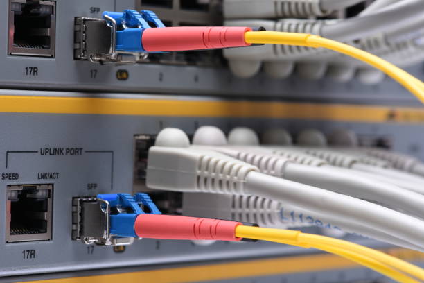 istock Ethernet network and fiber optic cable connected to internet switch 871946554