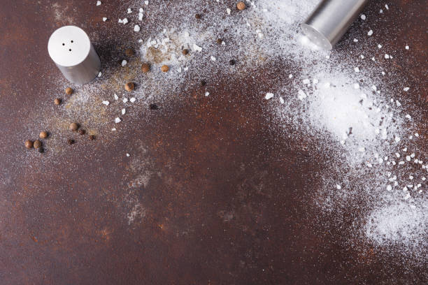 istock Scattered salt and pepper on dark background 871946682