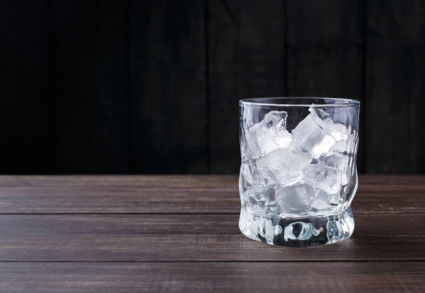 istock Glass with ice cubes on dark background 871946926