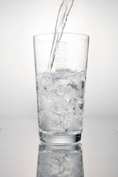 istock Pouring water on glass and ice cube 871947740