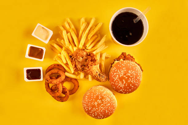 istock Fast food concept with greasy fried restaurant take out as onion rings, burger, fried chicken and french fries as a symbol of diet temptation resulting in unhealthy nutrition 871948842