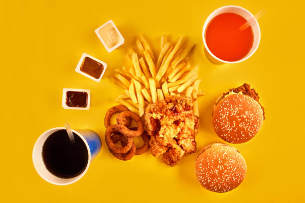 istock Fast food concept with greasy fried restaurant take out as onion rings, burger, fried chicken and french fries as a symbol of diet temptation resulting in unhealthy nutrition 871949086