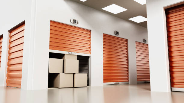 istock Open self storage unit full of cardboard boxes among closed doors 871955900