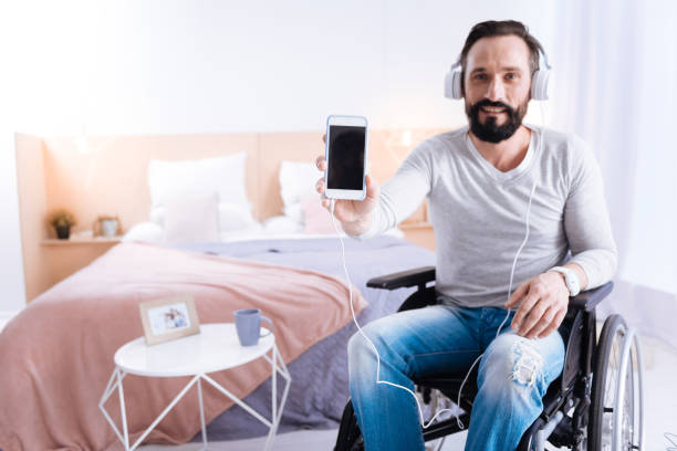 istock Exuberant paralyzed man showing his phone 871958002